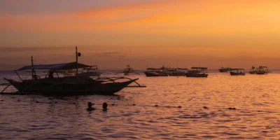Bateaux de pêche en mer au coucher du soleil au large de Bohol, Philippines