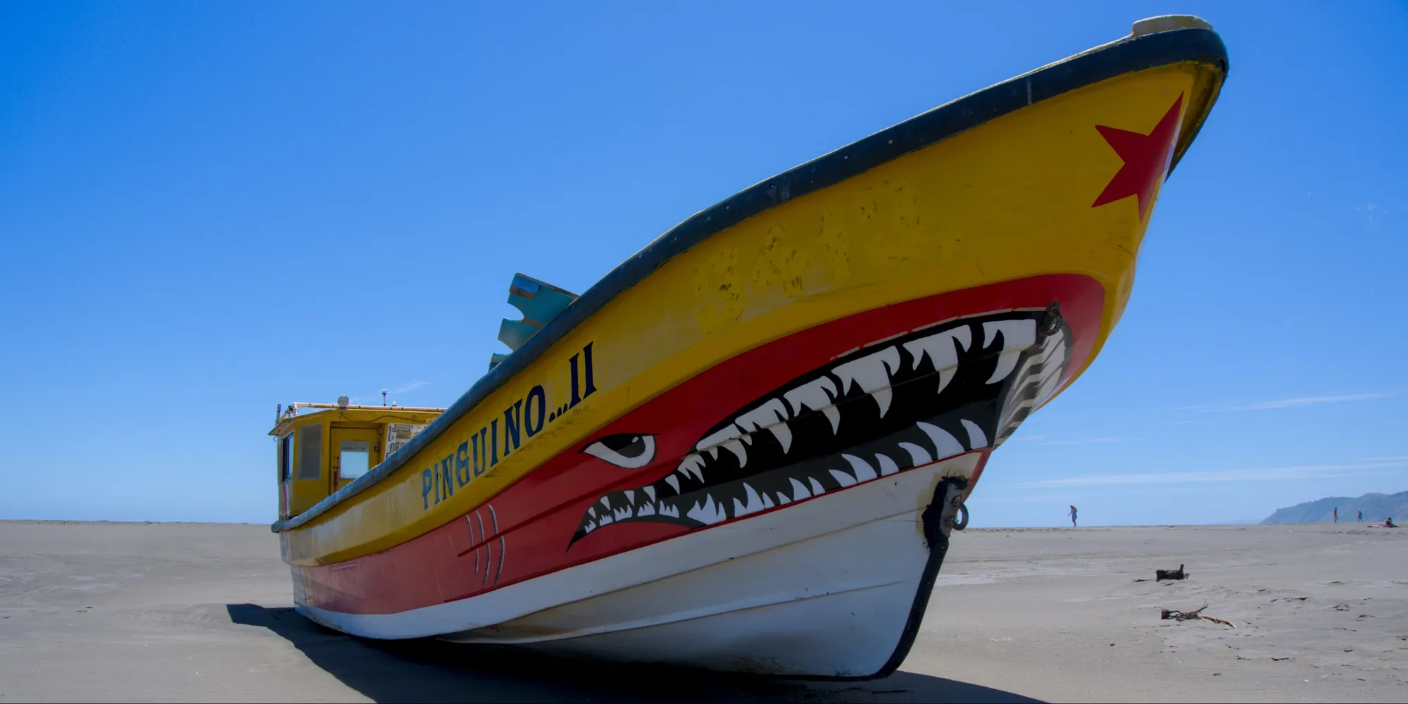 Chili — bateau coloré avec une peinture représentant une morsure de requin sur une plage de sable