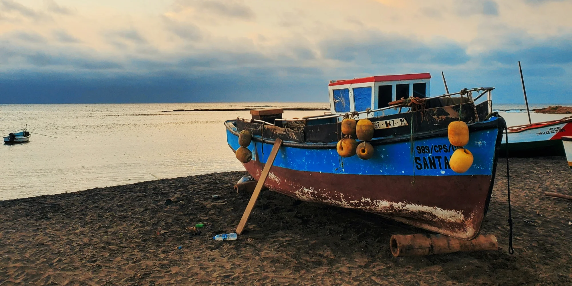 Plage du Cap-Vert avec vue sur la mer et petit bateau de pêche bleu – plongée avec les requins