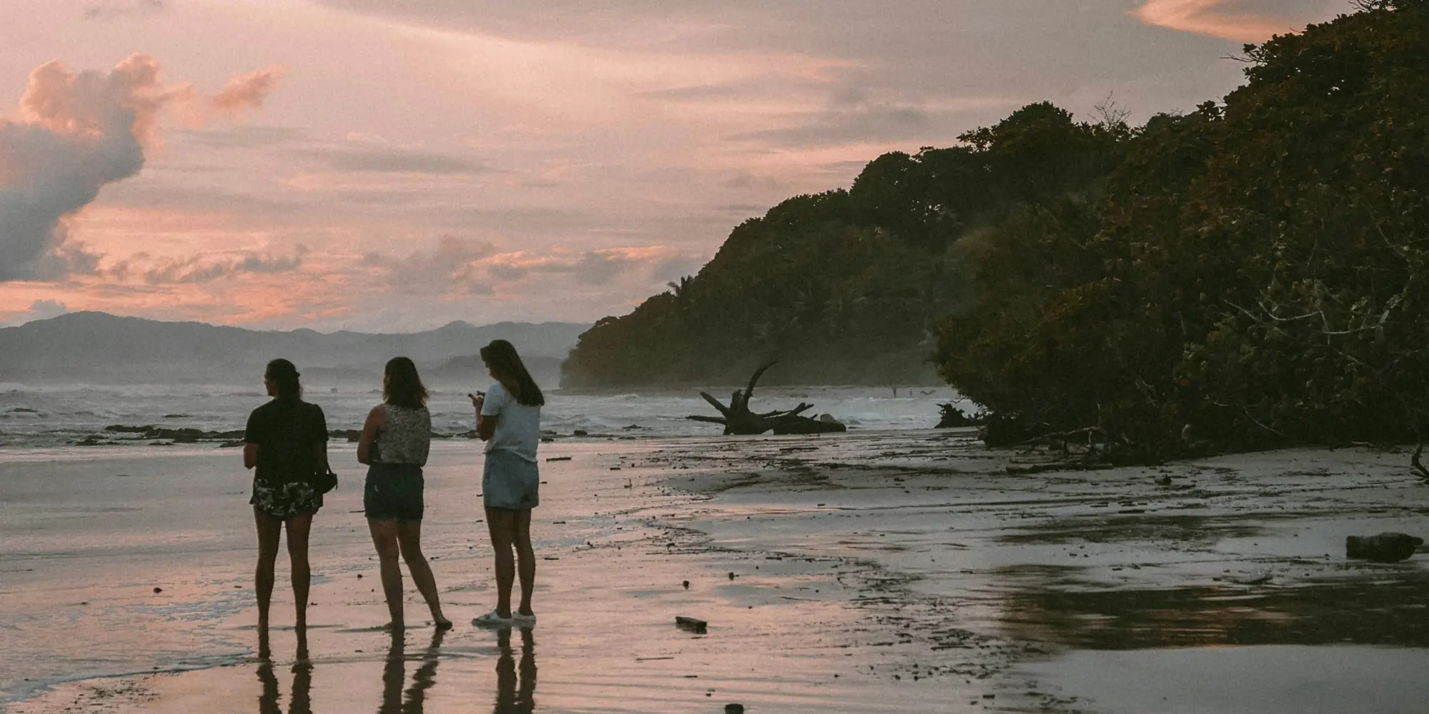 Trois personnes sur la plage au coucher du soleil au Costa Rica plongée avec des requins