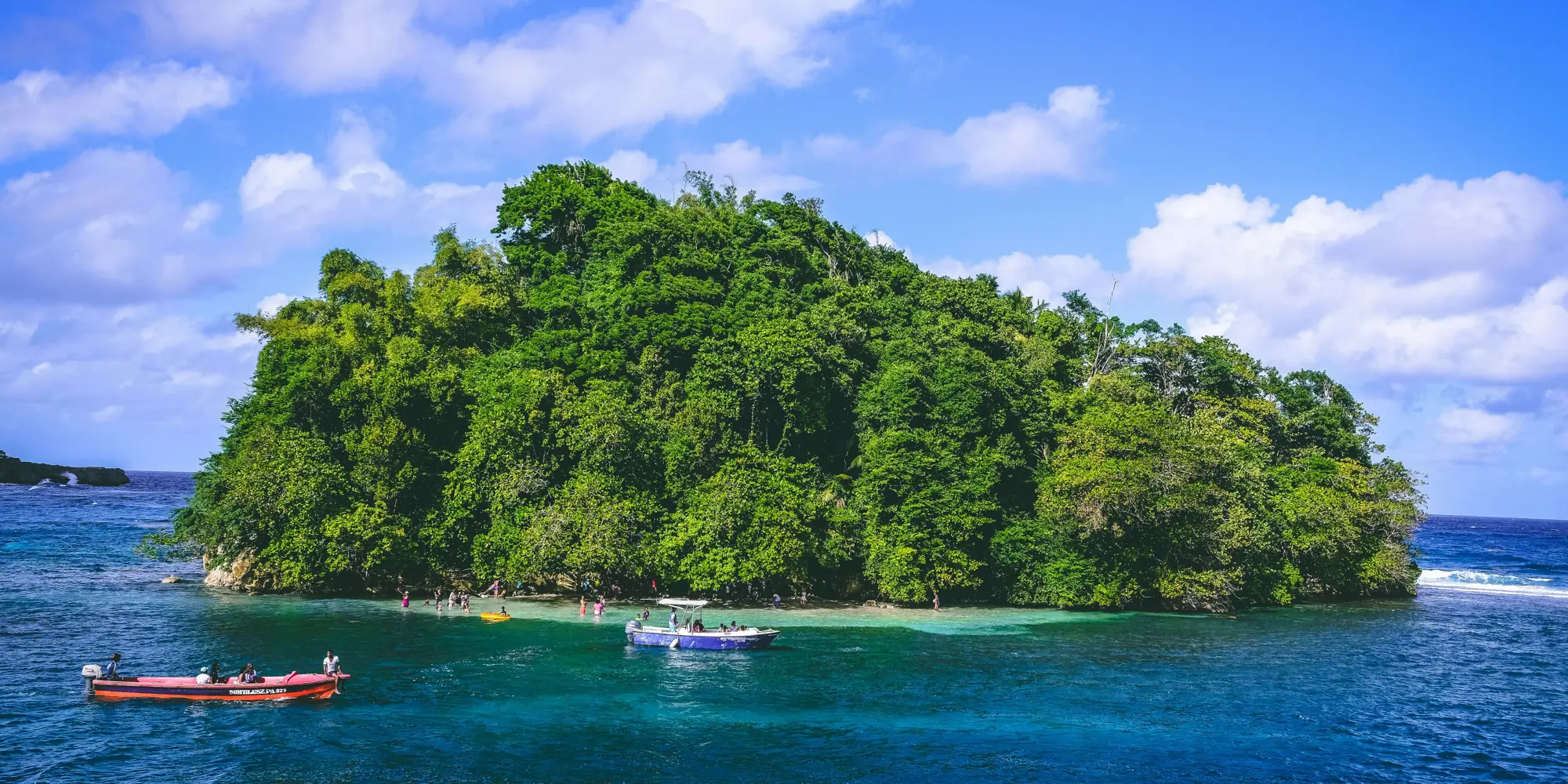 Petite île verte avec des bateaux dans la mer au large de la Jamaïque plongée avec des requins