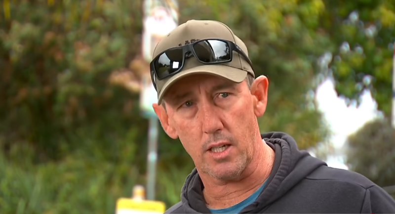 Le surfeur Matthew Devine portant une casquette avec des lunettes de soleil sur la visière lors d'une interview
